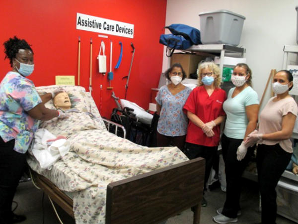 a group of people standing around a bed