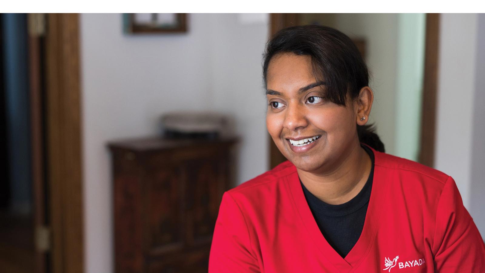 a woman smiling in a red shirt