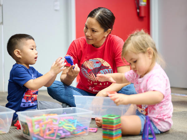 a woman and children playing with toys