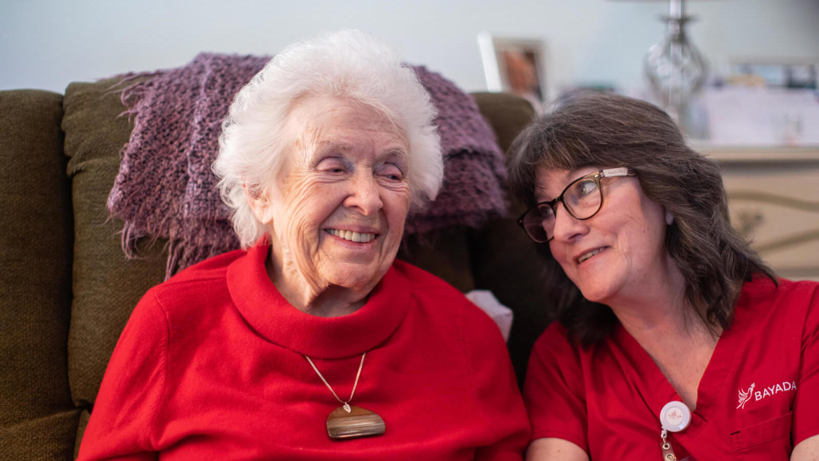 two women sitting on a couch