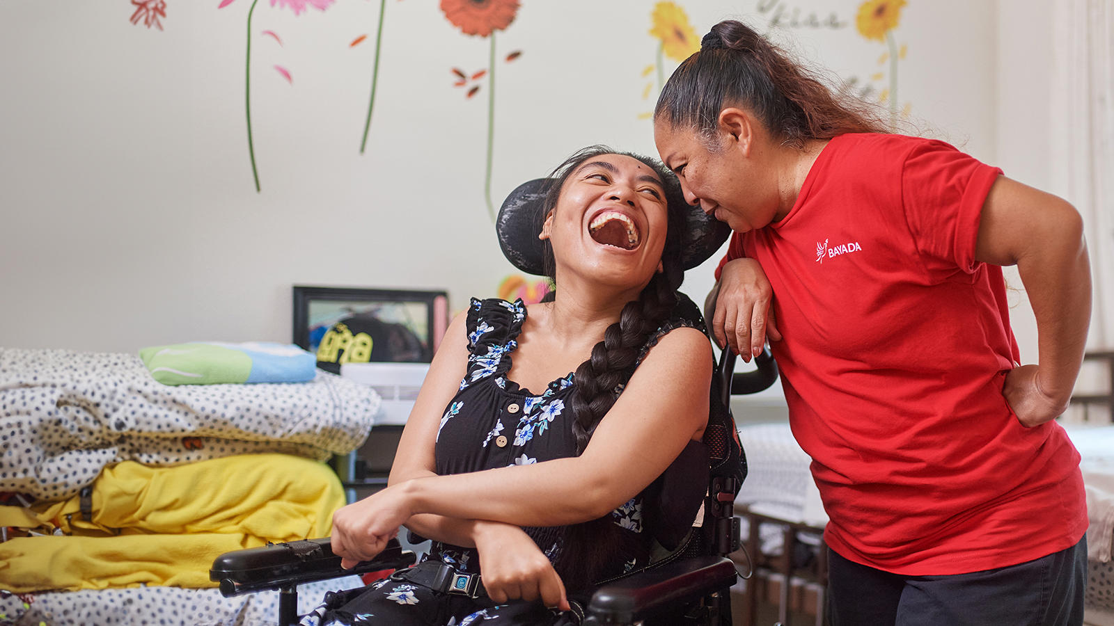a woman laughing while sitting in a wheelchair
