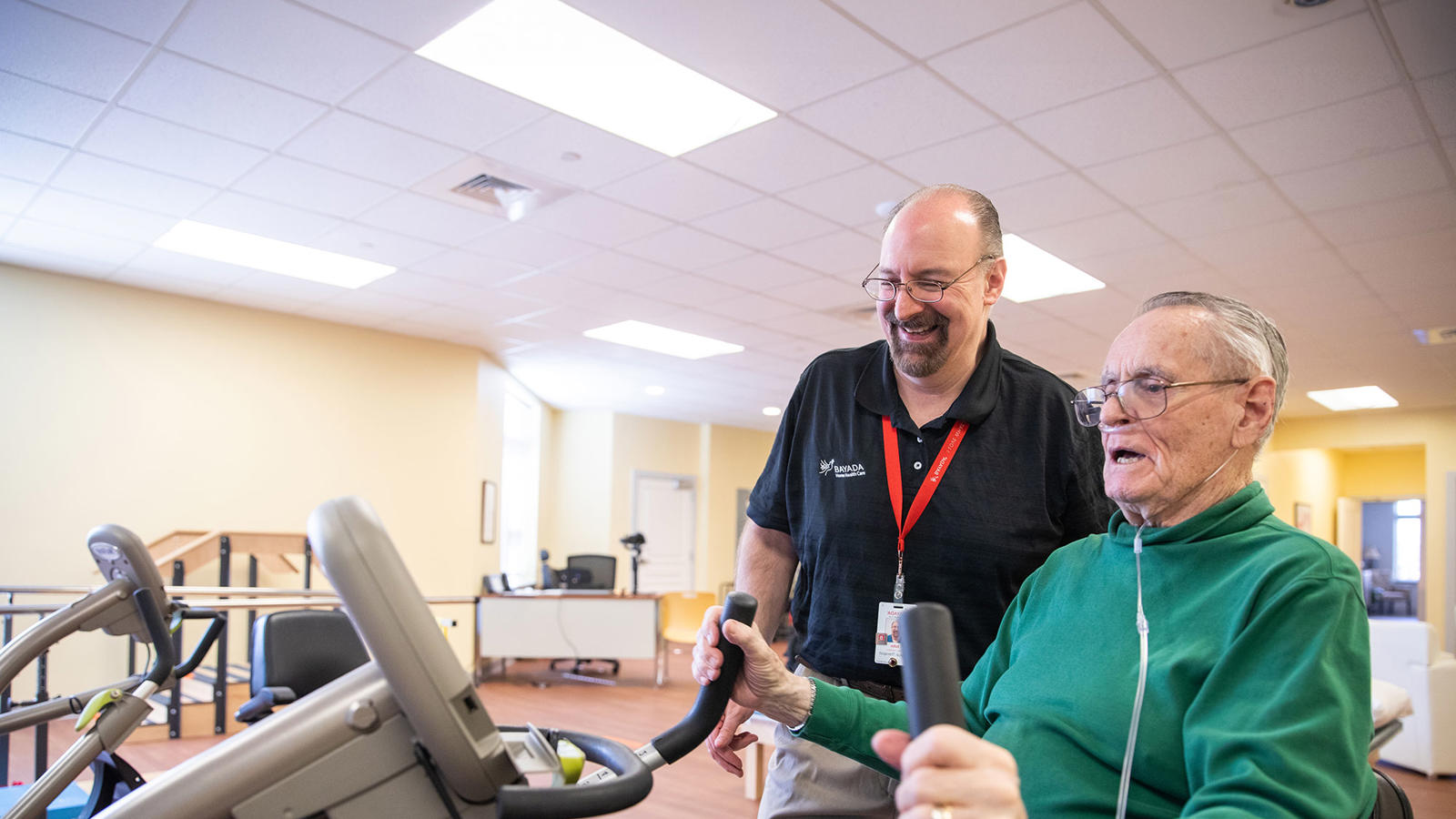 a man on an exercise bike with a man in the background