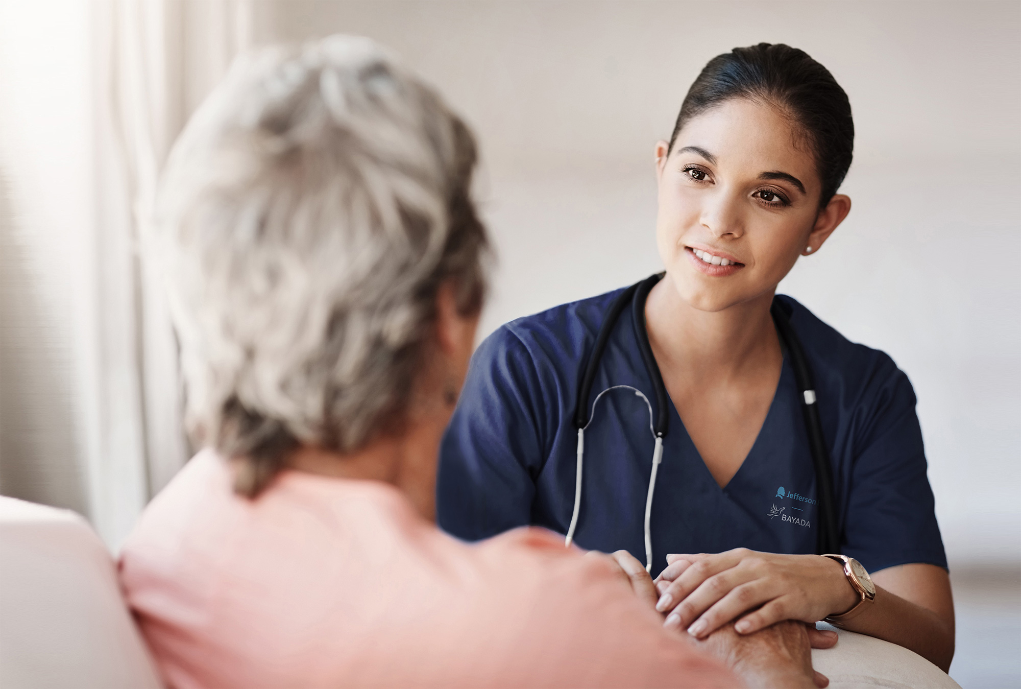 a woman in blue scrubs talking to a patient