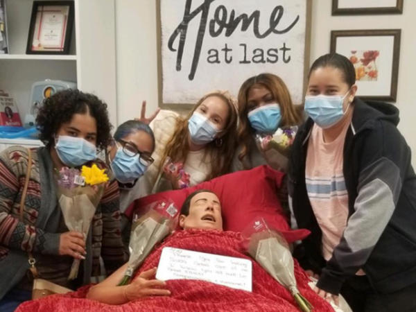 a group of people posing for a picture with a man in a bed