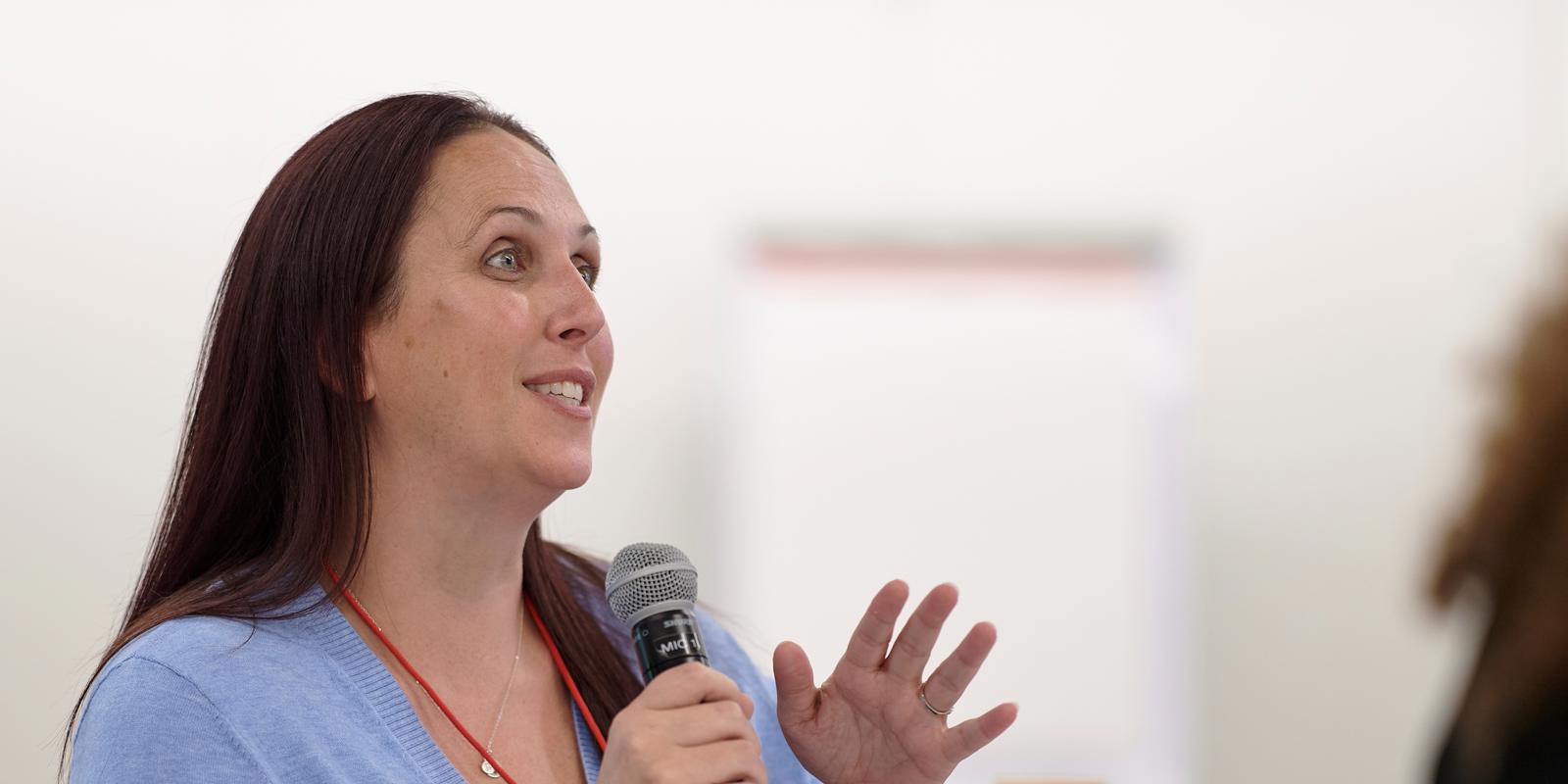 a woman speaking into a microphone
