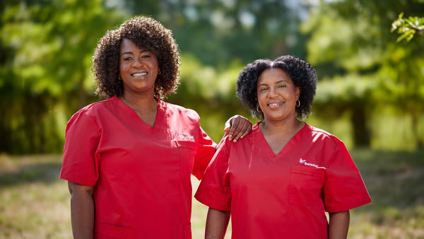 a group of women wearing red scrubs