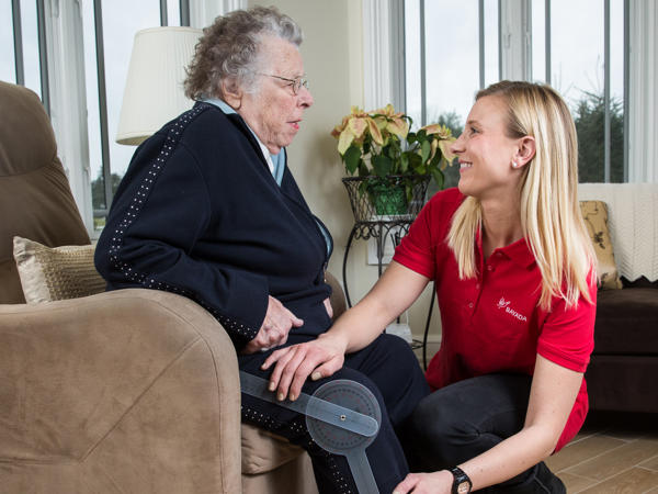 a woman sitting on a chair with an old woman