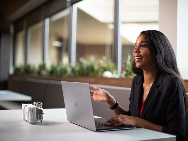 a woman sitting at a table with a laptop